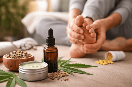 Woman rubbing foot where she feels neuropathy pain. Pills, CBD Balm, and CBD oil are nearby.